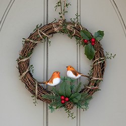 christmas wreath with berries and pinecones on front door